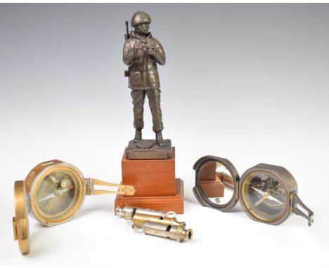 Two modern compasses, both marked Briton Compass Mk1 1862, two ARP whistles and a United Nations figure on a plinth