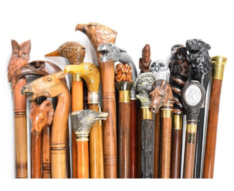 Approximately twenty walking sticks / canes in an oak umbrella or stick stand, the sticks include carved dog, bird and horse 