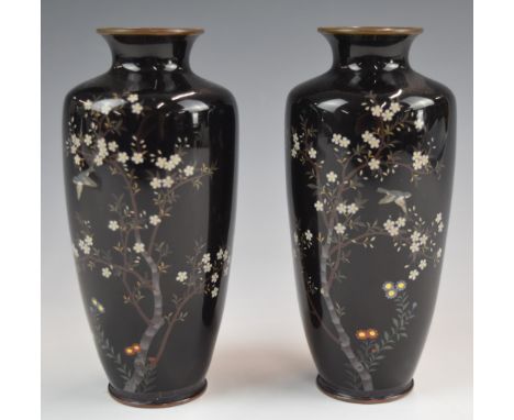 A pair of Japanese cloisonné vases decorated in enamel with birds, trees and flowers on a dark blue ground, height 15cm