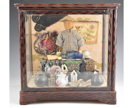 Chinese 'Door of Hope' doll diorama of a shopkeeper with a collection of wares including Chinese silver figure, embroidery, b