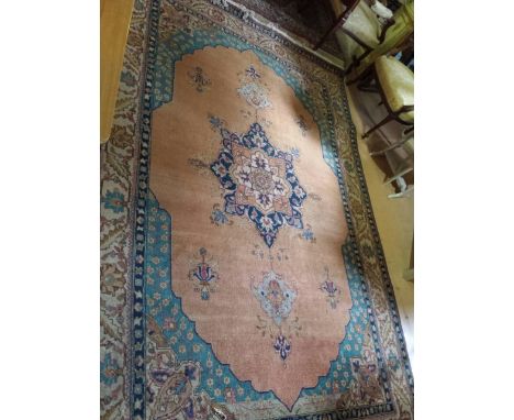 Large Iranian rug / carpet, on a pink ground with turquoise and navy blue feature colours 300 cm x 203 cm. One small bare are