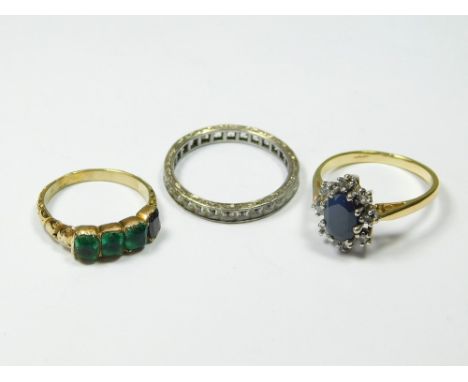 GOLD RINGS. A modern cubic zirconia & sapphire cluster ring in unmarked yellow metal, a modern eternity ring set with clear p