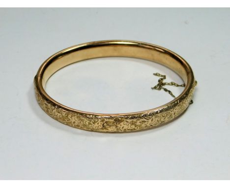 GOLD BANGLE. A 10ct. gold hinged bangle. Approx. 12.39g.  Please note that all items in this auction are previously owned & a