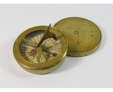 POCKET COMPASS/SUNDIAL. An early brass pocket compass/sundial with printed paper dial & folding gnomon. Diameter 5.7cm.  Plea