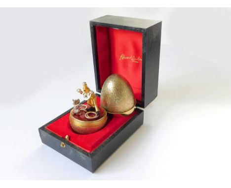 STUART DEVLIN. A Stuart Devlin, textured silver gilt Surprise Egg, opening to reveal a juggling clown & his dog on red enamel