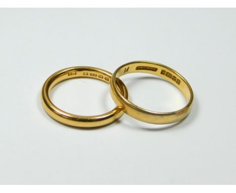 WEDDING BANDS. Two 22ct. gold wedding bands. Approx. 8.55g. The more rounded ring on the left hand side is a size L/M. The sl