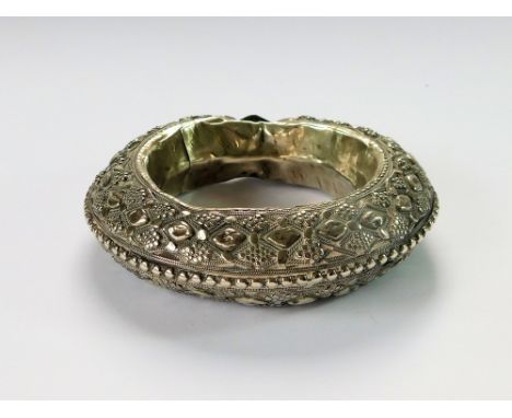 ANKLE BRACELET. An Indian silver-coloured metal, ornate anklet, probably a dowry item. External diameter, 11cm. Internal diam