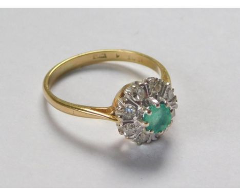 GOLD RING. A 1960's emerald & diamond cluster ring. London 1967. Approx. 3.3g. Size N.  Please note that all items in this au