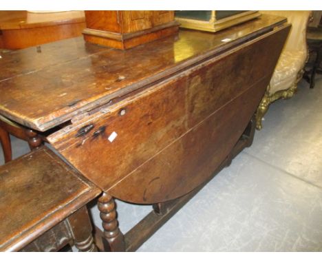 18th Century oak oval gate leg table, the plank top above a single end drawer raised on bobbin turned supports with stretcher