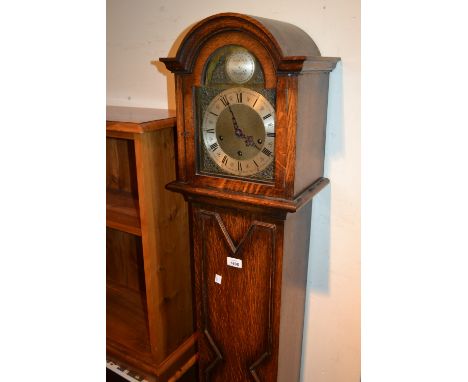 20th Century oak grandmother clock, the arched hood above a moulded trunk and conforming plinth base, the brass dial with sil