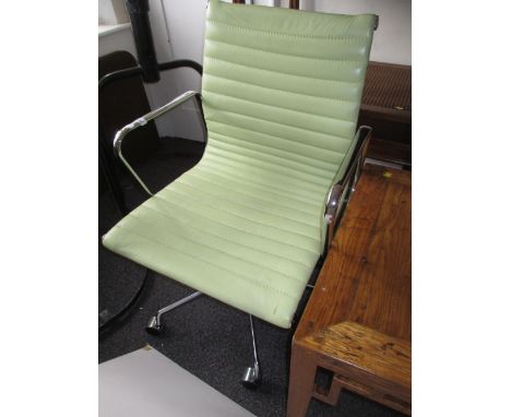Modern chrome and light green upholstered adjustable swivel office armchair on a chrome base with casters