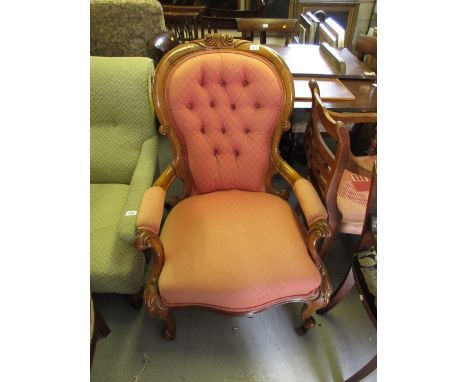 Victorian carved walnut and button upholstered open armchair, the spoon back above an overstuffed seat and cabriole supports 