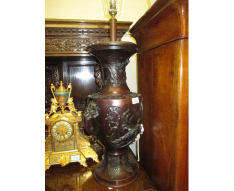Large patinated bronze oriental lamp base having dragon head handles and bird and dragon decoration in high relief, with shad