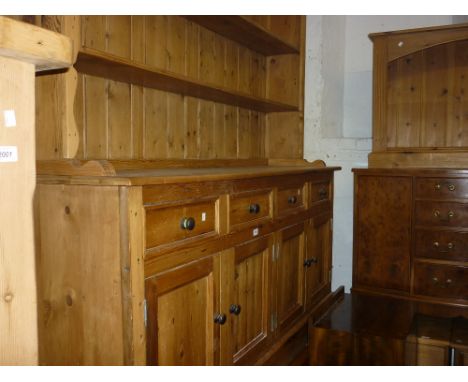 Large modern polished pine dresser having shelf back above four short drawers and four panelled doors with knob handles raise