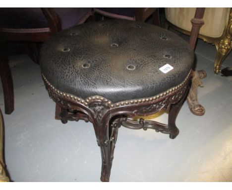 19th Century mahogany circular stool having floral carved decoration and crossover stretcher, with simulated black leather bu