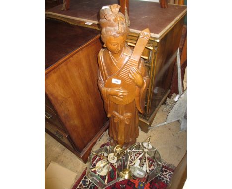 Large Indonesian carved figure of an oriental lady with an instrument together with two brass and glass hanging light fitting