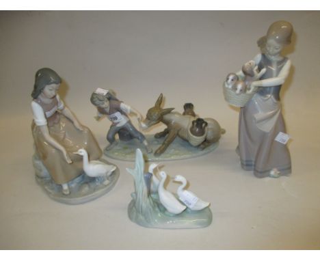 Lladro group of a boy and donkey, Lladro figure of a girl with a basket of puppies together with two Nao groups