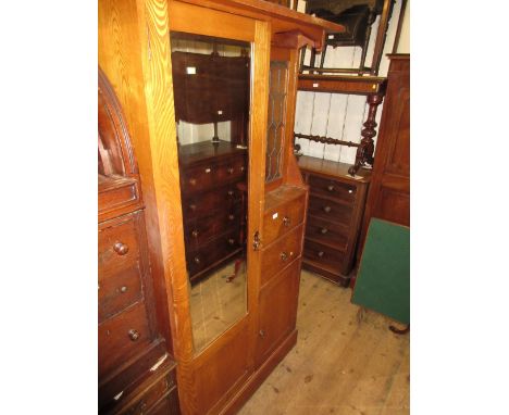 Arts and Crafts ash wardrobe with single mirrored door beside a leaded glass panel door, two drawers and a panel door on a pl