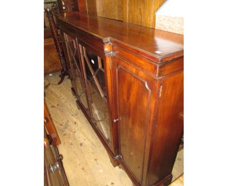 Mahogany breakfront bookcase, the moulded top above two astragal glazed door enclosing adjustable shelves, flanked by two pan