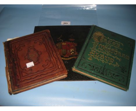 Late 19th Century embossed leather bound book of crests and another canvas bound, heavily decorated green and gilt bound volu