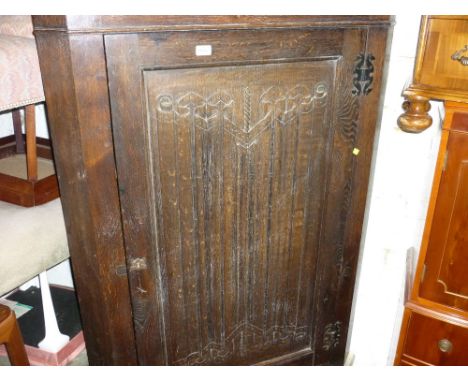 Early 20th Century oak standing corner cabinet with a single linen fold carved panel door