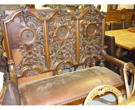 19th Century Continental carved oak hall bench, the triple pierced carved panel back above a leather covered seat, the arms w