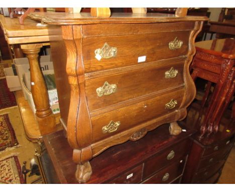 Small continental oak bombe commode chest of three drawers, raised on claw and ball supports