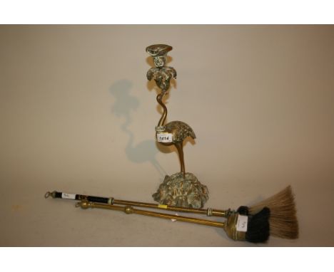19th Century brass candlestick on heron support, together with two brass fire brushes