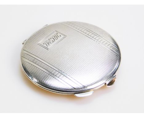 An Elizabeth II silver powder compact, of circular outline, partially engine turned, the hinge lid initialled E P H, revealin