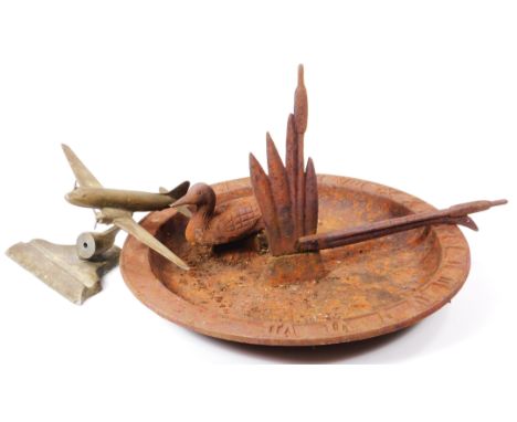 A sundial top, set with duck and stylised reed pointer, with lipped outline, 32cm dia., and a metal aeroplane from an ink sta