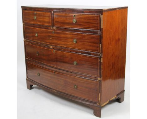 An early 19thC mahogany free standing bow front chest, the crossbanded top raised above two short and three long cock beaded 