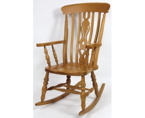 A 20thC light beech Windsor style rocking chair, with overhanging comb top, serpentine pierced back splat, shaped arms, ring 