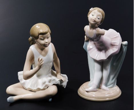 A Nao Lladro figure of a girl ballerina, standing in bowing pose, 18cm high, and another seated. (2, AF, boxed)