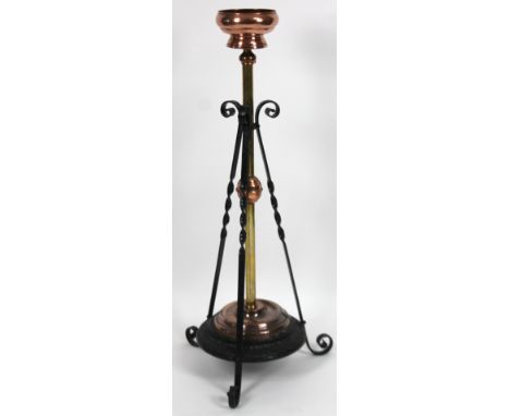 An early 20thC iron and copper gas lamp come jardiniere, with shallow dish top, cylindrical stem, scroll supports and a lower