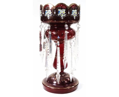 A Victorian ruby glass lustre, the castellated top partially painted with flowers, on a tapering cylindrical stem and domed f
