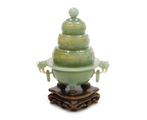 A Chinese jade incense burner, of five tiered construction, with carved scrolling decoration, on stand, boxed, 18.5cm high.