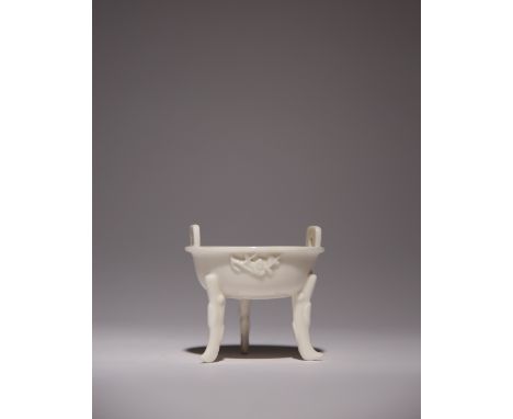 A SMALL CHINESE BLANC DE CHINE TWO-HANDLED TRIPOD INCENSE BURNER 17TH/EARLY 18TH CENTURY The shallow body decorated in relief