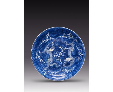 A LARGE CHINESE BLUE AND WHITE 'DRAGON' DISH KANGXI 1662-1722 With a gently flared rim, painted with two white fierce scaly d