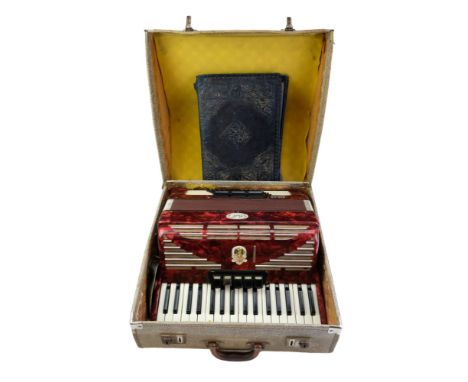 A cased Bell Serino accordion and sheet music