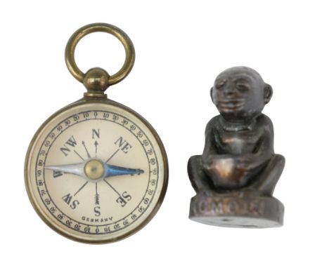 A 1924 Wembley British Empire Exhibition Nomori charm together with a miniature magnetic compass, former 28 mm. [Nomori figur