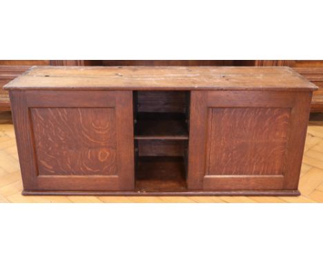 An early 20th Century oak two-door wall cabinet, having a central niche with adjustable shelf, 95 cm c 29 cm x 38 cm