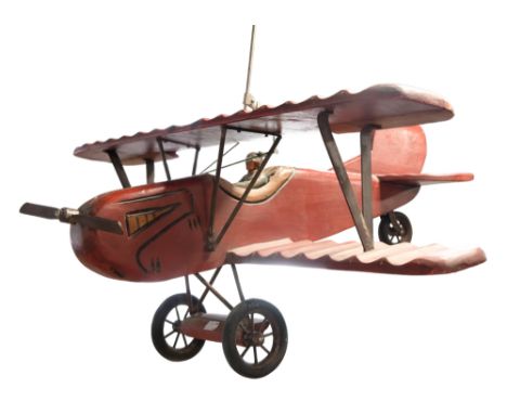 A large-scale carved-wood and steel model biplane and pilot, mid-to-late 20th Century, 74 cm wingspan x 68 cm length 