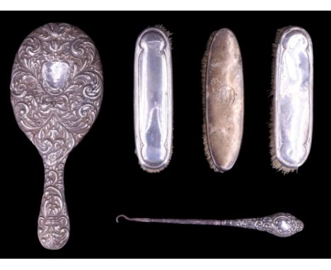 A silver-handled button hook together with a pair of silver-backed hair brushes and a hand mirror