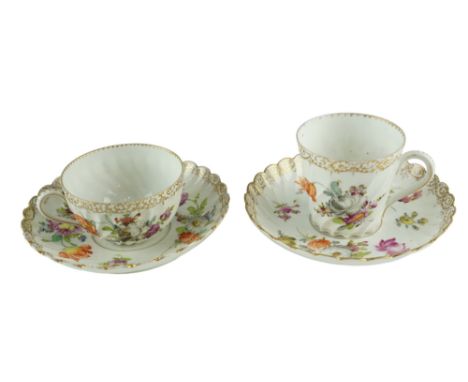 Two late 19th / early 20th Century Dresden cups and saucers, of spiral fluted form, decorated with hand-enamelled flora and g