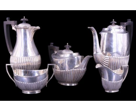 An early 20th Century silver four-piece tea service, in a Georgian gadrooned pattern with ebony mounts, Daniel George Collins