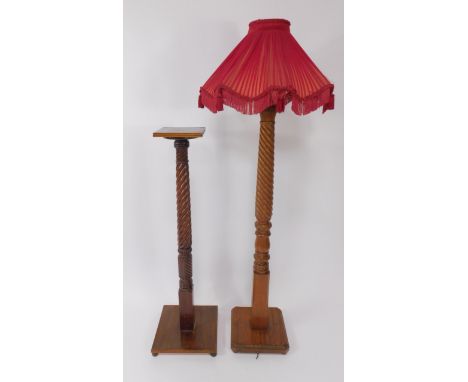 An early 20thC mahogany standard lamp, with turned and wrythen fluting, raised on a canted and carved square base, with shade