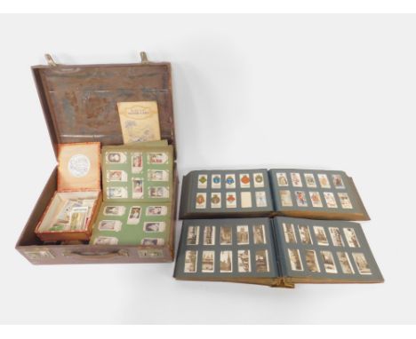 Two albums of cigarette cards, chiefly part sets, including Players Racing Caricatures, Carreras Fortune Telling, Happy Famil