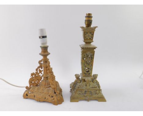 A Victorian brass candlestick, pierced and embossed with figural heads, wreaths and foliate scrolls, raised on a stepped squa