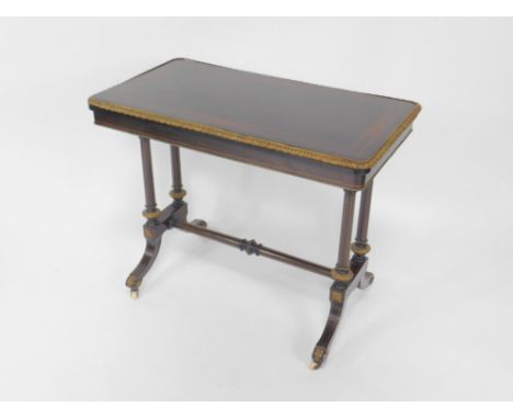 A Victorian ebonised and gilt brass fold over card table, with satinwood line and foliate inlay, opening to reveal a green ba