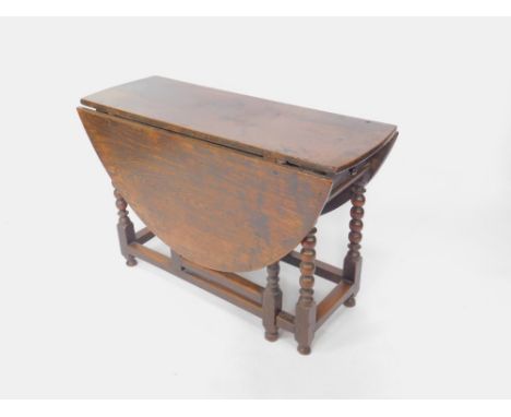 An 18thC oak drop leaf dining table, with single frieze end drawer, raised on bobbin turned legs, united by stretchers, 72cm 